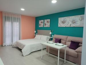 a bedroom with a bed and a couch at Estudios La Casina in Cáceres