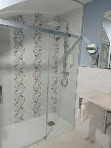 a shower with a glass door next to a sink at Estudios La Casina in Cáceres