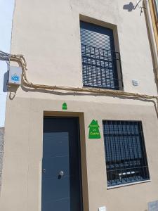un edificio con una puerta y una señal en él en Estudios La Casina, en Cáceres