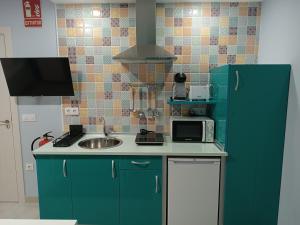 a kitchen with a green refrigerator and a sink at Estudios La Casina in Cáceres +25 photos