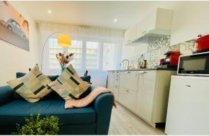 a living room with a blue couch in a kitchen at Appartement Cosy Metz Sablons in Metz +6 photos