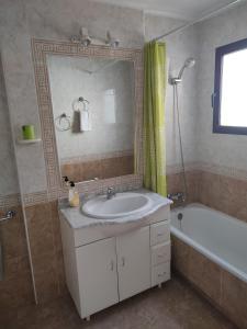 een badkamer met een wastafel, een bad en een spiegel bij Costamarina Apartments in Cabo Roig
