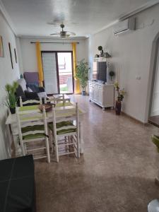 een woonkamer met een tafel en stoelen bij Costamarina Apartments in Cabo Roig
