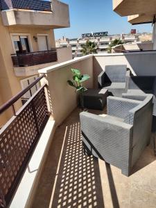 een balkon met stoelen en een plant op een gebouw bij Costamarina Apartments in Cabo Roig
