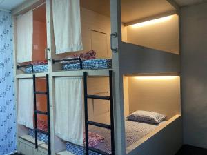a room with three bunk beds in a room at Stop @Melaka Guesthouse in Melaka