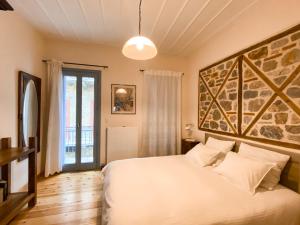 um quarto com uma cama branca e uma grande parede em Μπαλκόνι em Nafplio