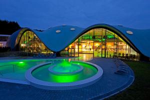 ein großes Gebäude mit Pool davor in der Unterkunft Hotel an der Therme in Bad Orb