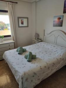 een slaapkamer met een bed met groene handdoeken erop bij Costamarina Apartment Top Floor in Cabo Roig