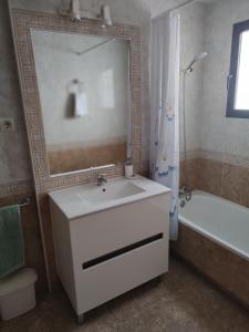 een badkamer met een wastafel, een spiegel en een bad bij Costamarina Apartment Top Floor in Cabo Roig