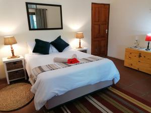 a bedroom with a bed with a red stuffed animal on it at Foundation Lodge in Sodwana Bay