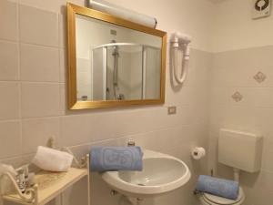 a bathroom with a sink and a mirror and a toilet at Centrale in Courmayeur