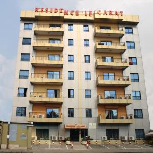 a tall white building with a sign on it at Residence Le Carat Silverline in Douala