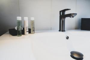 Un lavabo con tres velas y un grifo. en Le Duplex atypique superbe coeur centre ville, en Annecy