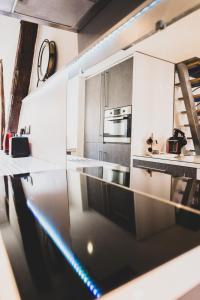 Una cocina con gabinetes blancos y encimera. en Le Duplex atypique superbe coeur centre ville, en Annecy