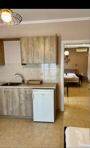 a kitchen with a sink and a refrigerator at Valedina Rooms in Nikiana