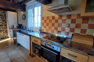 kuchnia ze zlewem i kuchenką w obiekcie Maison La Denolais Carnet Mont-Saint-Michel w mieście Saint-James