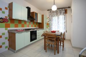 a kitchen with a table and chairs and a kitchen with white cabinets at Villa Roswal in Rosolina Mare