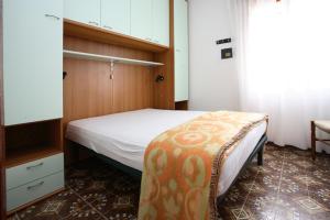 um pequeno quarto com uma cama e uma cómoda em Villa Roswal em Rosolina Mare