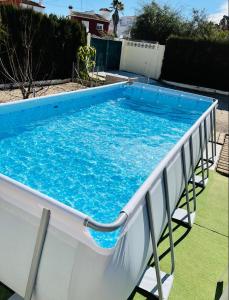 een groot zwembad met blauw water in een tuin bij The House in Casas Devesa