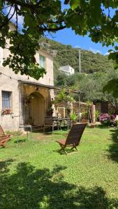 菲納萊利古雷的住宿－Casa Olivia Lacremà，房屋前有长凳的院子