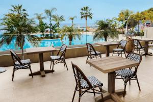 a patio with tables and chairs and a pool at Royal Apollonia by Louis Hotels in Limassol