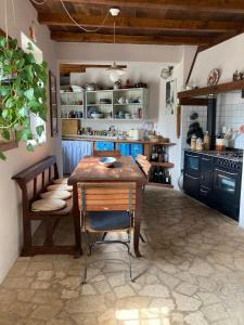 Casa Olivia Lacremà في فينالي ليغوري: مطبخ مع طاولة وكراسي خشبية