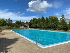 a large blue swimming pool with trees in the background at Hotel Cemar in Mondariz