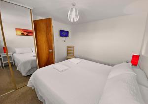 a bedroom with two beds and a mirror at Waterfront Quay in Gosport