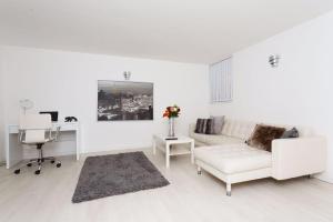 a white living room with a white couch and a desk at Nazarene apartments in Leeds in Stanningley