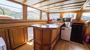 una cocina con armarios de madera y una barra en un barco en Hka Neta Yachting en Fethiye