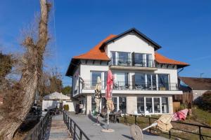 a large white house with an orange roof at Duna P'Art Panzió in Verőce