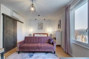 sala de estar con sofá púrpura y ventana en Duna P'Art Panzió, en Kismaros