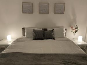 una camera da letto con un grande letto con due lampade sopra di Spacious Apartment - Contractors and Family - LGW a Horley