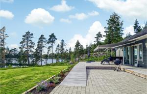 a house with a porch and a patio at Awesome Home In Smedjebacken With House Sea View in Smedjebacken