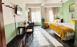 Hotel Darwin في كاتماندو: فندق غرفه بسرير ومكتب وسرير