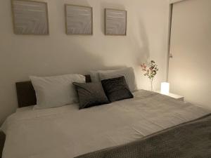 um quarto com uma grande cama branca com almofadas em Spacious Apartment - Contractors and Family - LGW em Horley