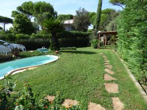 a backyard with a swimming pool and a yard with a grassy yard sidx sidx at Casa Vannini in Tirrenia
