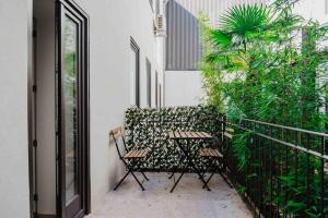 een patio met 2 stoelen en een hek met planten bij Downtown Terrace Flat with AC and Patio - feel like a local in Porto