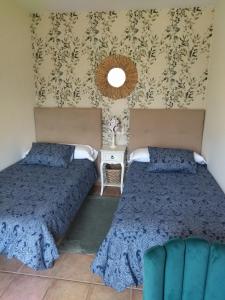 1 Schlafzimmer mit 2 Betten und einem Wandspiegel in der Unterkunft El Cerrón in Llanes