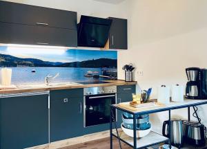 a kitchen with blue cabinets and a counter with a view of the water at Ferienwohnung Niki in Titisee-Neustadt