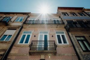 - un bâtiment avec un balcon et le soleil au ciel dans l'établissement Green Garden Luxury House w/ AC, Metro & Downtown, à Porto