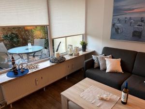ein Wohnzimmer mit einem Sofa und einem Tisch in der Unterkunft Seeschlösschen 1-07 in Grömitz