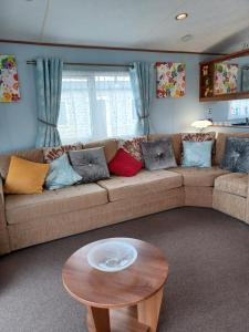 a living room with a couch and a table at Vista Caravan Hire in Seasalter
