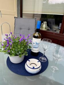 eine Flasche Wein und zwei Gläser und Blumen auf dem Tisch in der Unterkunft Seeschlösschen 1-07 in Grömitz