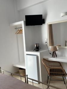 una camera con TV, sedia e specchio di Hotel Chrisoula a Città di Antiparo