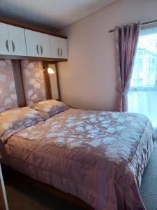 a bedroom with a bed and a window at Vista Caravan Hire in Seasalter +25 photos