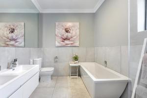 a bathroom with a tub and a sink and a toilet at 2 On Lismore Guesthouse in Tokai