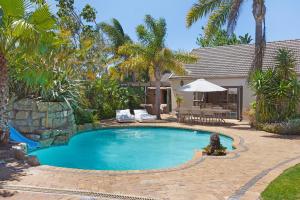 a swimming pool in a yard with palm trees at 2 On Lismore Guesthouse in Tokai