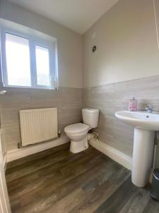 a bathroom with a toilet and a sink and a window at Hosted By Ryan - 1 Bedroom House in Liverpool