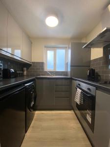 a kitchen with a sink and a stove top oven at Hosted By Ryan - 1 Bedroom House in Liverpool
